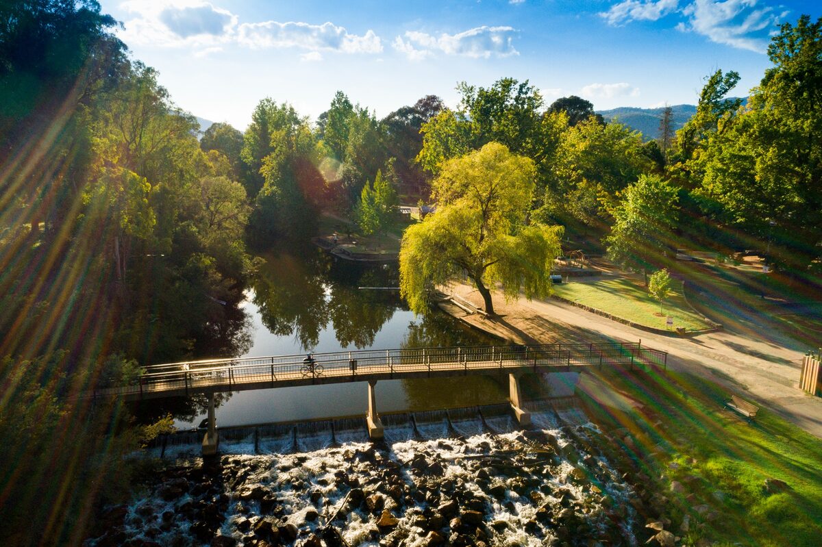 Sunlit footbridge over the river in Bright